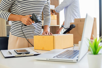 Midsection of man using laptop on table