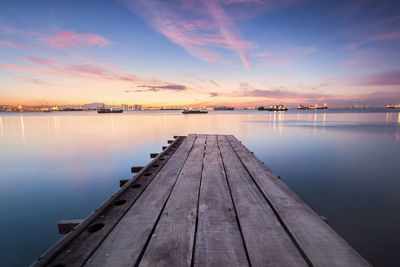 Pier over sea against sky during sunset