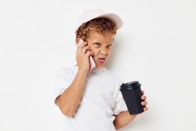 Boy making face while talking on phone