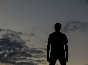 Rear view of silhouette man standing against sky