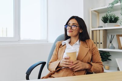 Young woman using mobile phone while sitting at home