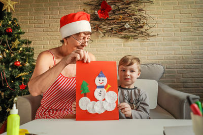 Grandmother and grandson making greeting card at home