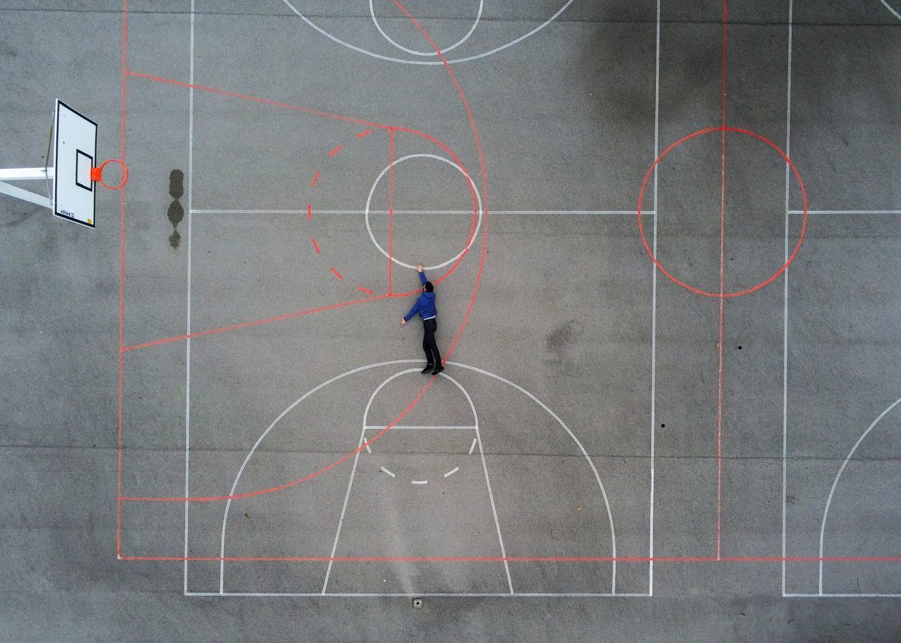 HIGH ANGLE VIEW OF MAN PLAYING BASKETBALL