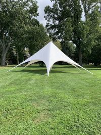 Tent on field against trees in park