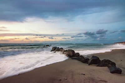 Scenic view of beach against sky during sunset