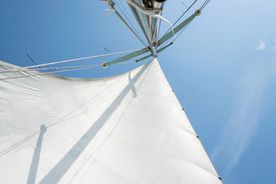 Low angle view of sailboat against clear blue sky