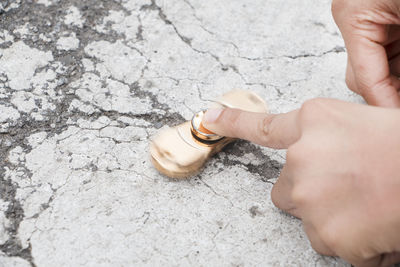 Cropped hands holding fidget spinner on road