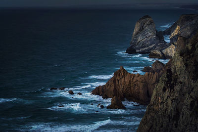 Rock formation in sea against sky