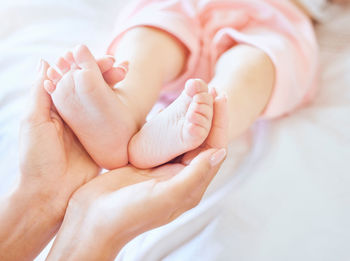 Low section of baby on bed