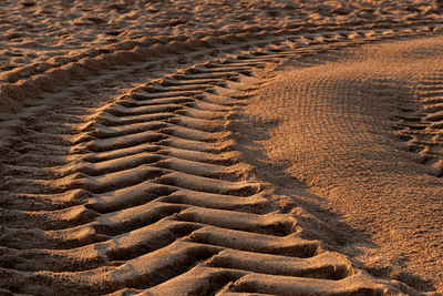 High angle view of tire tracks on sand