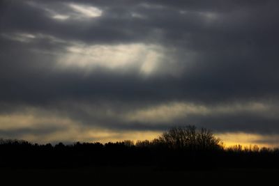 Scenic view of dramatic sky over silhouette trees