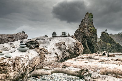 Statue by rock formation against sky