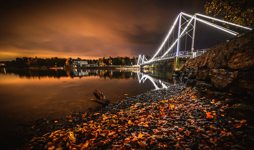 Bridge over river against sky at night