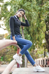 Full length of young woman against tree