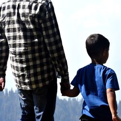Father and son holding hands while standing outdoors
