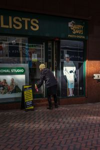 Rear view of man walking on street in city