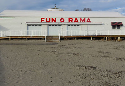 Information sign on beach against sky