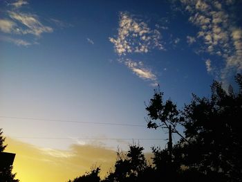 Low angle view of silhouette trees against sky