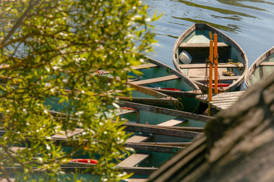 Small boat moored in lake against trees