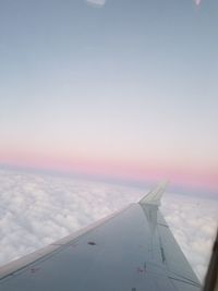 Airplane flying in sky during sunset