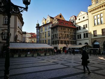 People walking in city against clear sky