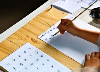 High angle view of hand  doing caligraphy