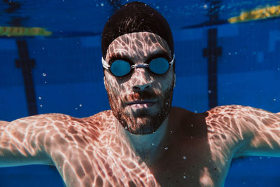 Portrait of young man swimming in pool