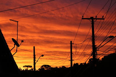 Low angle view of silhouette electricity pylon against romantic sky