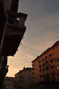 Low angle view of buildings in city during sunset