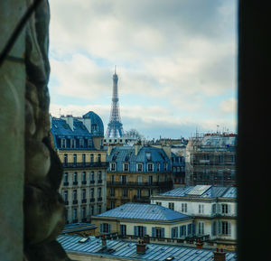 Buildings in city against cloudy sky