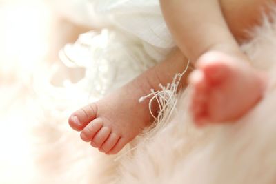 Low section of baby feet on bed