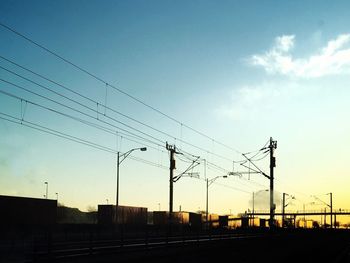 Silhouette railroad tracks against sky during sunset
