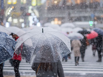 People walking on wet street during rainy season