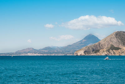 Scenic view of sea and mountains against sky