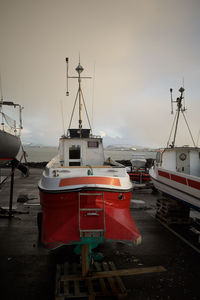 Boats moored at harbor against sky during sunset