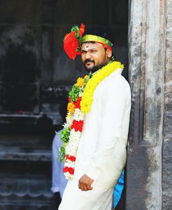 Portrait of groom standing by wall