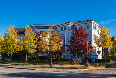 Street by building against clear blue sky