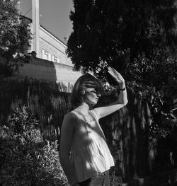 Teenage girl shielding eyes while standing outdoors