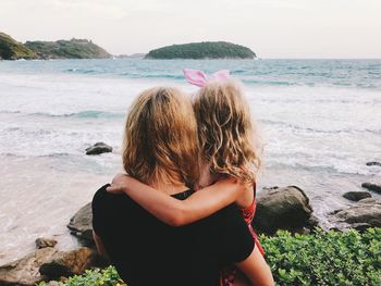 Mother and daughter looking at sea