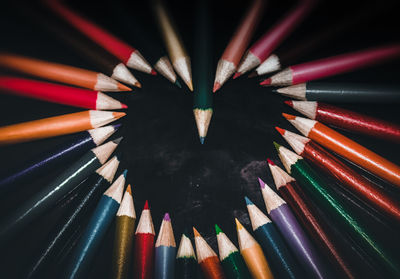 High angle view of multi colored pencils on table against black background