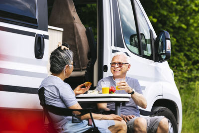 Senior couple sitting in front of trailer