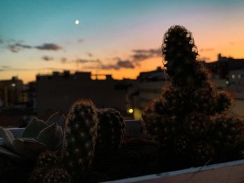 Illuminated cityscape against sky at dusk