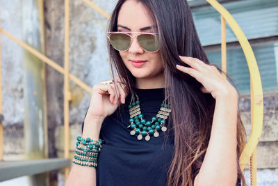 Young woman wearing sunglasses and jewelry outdoors