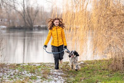 Portrait of young woman standing by lake