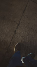 Low section of person standing on hardwood floor