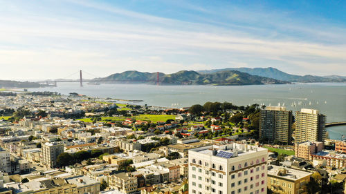 High angle view of city by sea against sky