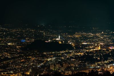 High angle view of illuminated cityscape against sky at night