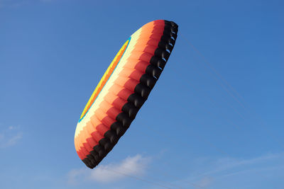 Low angle view of multi colored flag against blue sky