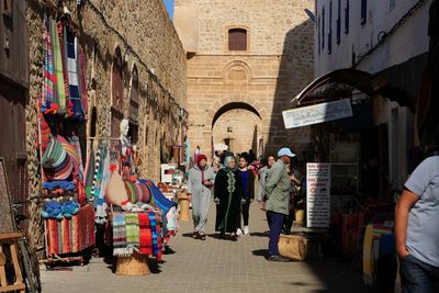 People walking on street amidst buildings in city