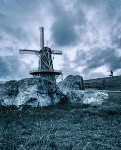 Traditional windmill on field against sky